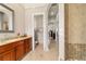 Bathroom featuring a single vanity, tile flooring, and access to a tiled shower behind a glass door at 3986 Se 43Rd Cir, Ocala, FL 34480