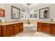 Bright bathroom featuring a soaking tub, dual vanities, arched windows with plantation shutters at 3986 Se 43Rd Cir, Ocala, FL 34480
