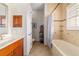 Bathroom featuring a single vanity, tile flooring, tiled shower/tub combination, and window with plantation shutters at 3986 Se 43Rd Cir, Ocala, FL 34480