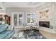 Bright living room showcasing a stone fireplace, French doors, and stylish seating at 3986 Se 43Rd Cir, Ocala, FL 34480
