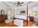 The main bedroom features hardwood floors, a ceiling fan, and a seating area near the window at 3986 Se 43Rd Cir, Ocala, FL 34480