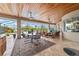 Covered patio features an outdoor dining area, comfortable seating, and views of the pool and backyard at 3986 Se 43Rd Cir, Ocala, FL 34480