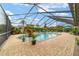 Sparkling pool with a screened enclosure, a spa, and a brick patio surrounded by lush greenery at 3986 Se 43Rd Cir, Ocala, FL 34480