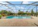Beautiful swimming pool with a screened enclosure, a spa, a brick patio, and lush landscaping at 3986 Se 43Rd Cir, Ocala, FL 34480