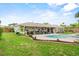 Spacious backyard features a covered patio, inground pool, and lush greenery, perfect for outdoor entertaining at 460 E Haines Blvd, Lake Alfred, FL 33850