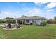 Large backyard offering an outdoor kitchen, dining area, a fire pit, lounge seating, and lovely landscaping at 460 E Haines Blvd, Lake Alfred, FL 33850