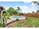 Lush backyard featuring a pool, lounge chairs, tropical landscaping, and a privacy fence at 460 E Haines Blvd, Lake Alfred, FL 33850
