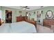 Bright bedroom with ceiling fan, large dresser and a view to the ensuite bathroom at 460 E Haines Blvd, Lake Alfred, FL 33850
