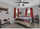 Comfortable bedroom featuring a decorative quilt, ceiling fan, and bright red curtains at 460 E Haines Blvd, Lake Alfred, FL 33850