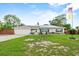 Charming single-story home featuring a lush green lawn, solar panels, and a lovely manicured lawn at 460 E Haines Blvd, Lake Alfred, FL 33850