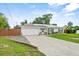 Well-maintained home featuring a spacious driveway, attached garage, lush lawn, and manicured landscaping at 460 E Haines Blvd, Lake Alfred, FL 33850