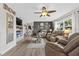 Cozy living room with a decorative fireplace, ceiling fan, and comfortable seating arrangement at 460 E Haines Blvd, Lake Alfred, FL 33850