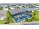 An aerial view of the house highlighting the expansive screened pool area and well-maintained surroundings at 488 Seth Run, The Villages, FL 32163