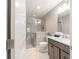 This is a bathroom with gray tile, modern fixtures, and a glass shower with a small plant on the shower ledge at 488 Seth Run, The Villages, FL 32163