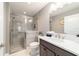 This bathroom has gray tile, modern fixtures, and a glass shower, and a small plant sitting on the counter at 488 Seth Run, The Villages, FL 32163
