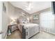 This bedroom features neutral walls and carpet, a ceiling fan, and a queen bed with beachy artwork at 488 Seth Run, The Villages, FL 32163