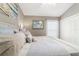 The bedroom features neutral walls and carpet, a queen-size bed with beachy artwork on the walls at 488 Seth Run, The Villages, FL 32163