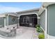 Inviting front porch with a screened-in enclosure, paver flooring, and decorative elements, providing a cozy outdoor space at 488 Seth Run, The Villages, FL 32163