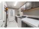 Laundry room with updated washer and dryer and dark brown cabinetry at 488 Seth Run, The Villages, FL 32163