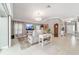 Bright living room with neutral decor, tile flooring, recliner seating, and elegant lighting at 488 Seth Run, The Villages, FL 32163