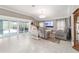 Open-concept living room featuring tiled flooring, sliding glass doors to the lanai, and comfortable seating areas at 488 Seth Run, The Villages, FL 32163