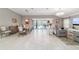 Spacious living room and dining area with tiled floors and sliding glass doors leading to the outdoor patio and pool at 488 Seth Run, The Villages, FL 32163