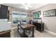 This home office has a ceiling fan, area rug, and a wooden desk with black metal supports and a black office chair at 488 Seth Run, The Villages, FL 32163