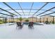 Sparkling pool area enclosed by a screened lanai with lounge chairs and dining at 488 Seth Run, The Villages, FL 32163