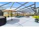 Relax on the sun deck by the screened pool with umbrella, surrounded by lush landscaping, creating a perfect outdoor retreat at 488 Seth Run, The Villages, FL 32163