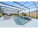 Sparkling pool area enclosed by a screened lanai with lounge chairs and dining at 488 Seth Run, The Villages, FL 32163