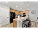 Charming kitchen with wood cabinets, granite counters, an island with bar seating and modern black appliances at 5133 Sw 41St Pl, Ocala, FL 34474