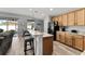 This open kitchen has wood cabinets, granite countertops, stainless appliances, and an island with bar stools at 5133 Sw 41St Pl, Ocala, FL 34474