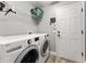 Laundry room features a full size washer and dryer, wire shelf and a door to the garage at 5133 Sw 41St Pl, Ocala, FL 34474