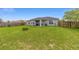 Large, grassy backyard featuring a covered patio area, offering plenty of space and privacy at 63 Walnut Crse, Ocala, FL 34480