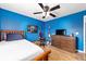 Well-lit bedroom featuring wood floors, a ceiling fan, and wall art at 63 Walnut Crse, Ocala, FL 34480
