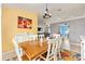 Bright dining room with wood table, floral rug, and decorative sideboard with colorful artwork at 63 Walnut Crse, Ocala, FL 34480