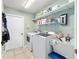 Functional laundry room with appliances, storage shelves, and utility sink at 63 Walnut Crse, Ocala, FL 34480