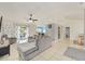 Spacious living room with tile floors, an open layout leading to the kitchen, and cozy gray sectional sofa at 63 Walnut Crse, Ocala, FL 34480
