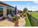 A backyard patio with comfortable lounge chairs, and a manicured lawn overlooking the golf course at 6776 Sw 95Th Cir, Ocala, FL 34481
