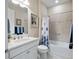 Well-lit bathroom showcasing a vanity, commode, tub/shower with a decorative blue shower curtain at 6776 Sw 95Th Cir, Ocala, FL 34481