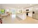 Bright kitchen features white cabinets, stainless steel appliances, tile floors, and an eat-in island at 7133 Sw 135Th Pl, Ocala, FL 34473