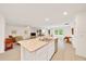 Open kitchen with a granite island overlooking a spacious living area for seamless entertaining and relaxation at 7133 Sw 135Th Pl, Ocala, FL 34473