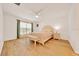 Light and bright main bedroom with hardwood floors, window, ceiling fan, and ensuite bathroom at 7133 Sw 135Th Pl, Ocala, FL 34473