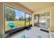 Enjoy backyard views through large windows from this screened porch with neutral colors and matching furniture at 7133 Sw 135Th Pl, Ocala, FL 34473