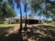 Backyard view, featuring an expansive screened lanai, mature trees, and a partially fenced in yard at 8100 Sw 56Th Ter, Ocala, FL 34476
