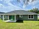 Spacious backyard featuring a covered patio and lush green lawn at 8289 Se 159Th Ln, Summerfield, FL 34491