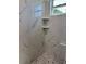 Shower showcasing marble-patterned tile, corner shelves, and a gray-tiled floor at 8289 Se 159Th Ln, Summerfield, FL 34491