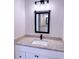 Bathroom with granite countertops, modern light fixture, black faucet, and black hardware accents at 8289 Se 159Th Ln, Summerfield, FL 34491