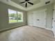 Bedroom featuring hardwood floors, a ceiling fan, a large window, and double door closet at 8289 Se 159Th Ln, Summerfield, FL 34491