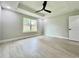 Bright bedroom featuring tray ceilings, ceiling fan, large windows, and light gray flooring at 8289 Se 159Th Ln, Summerfield, FL 34491
